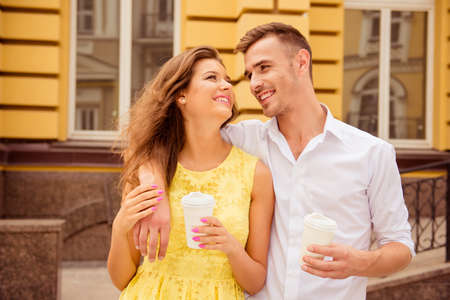 lovers walking street with coffee