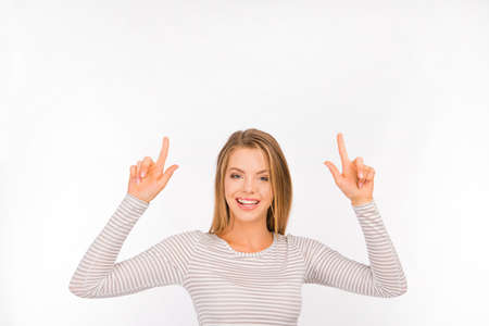 Smiling pretty young girl pointing awayの写真素材