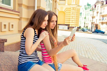 Young woman makes selfe photo on a digital tabletの写真素材