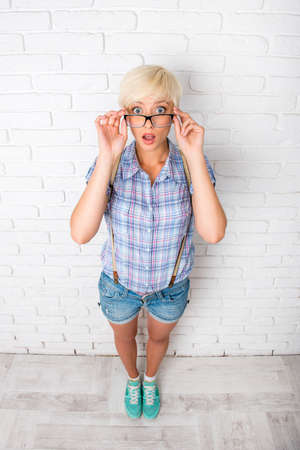 surprised girl adjusts his glassesの写真素材