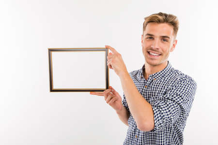 Handsome man holding a picture frameの写真素材