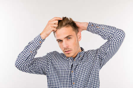 handsome young man brushing his hairの写真素材