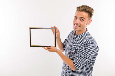 Handsome man holding a picture frameの写真素材