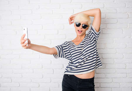 girl with glasses making selfie