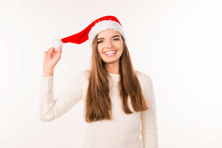 cheerful girl holding santa hatの写真素材