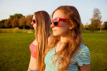 Two pretty young girls watching beautiful sunsetの写真素材