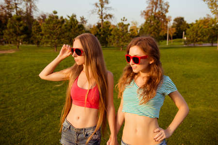 two intriguing sexy girls looking at the sunsetの写真素材