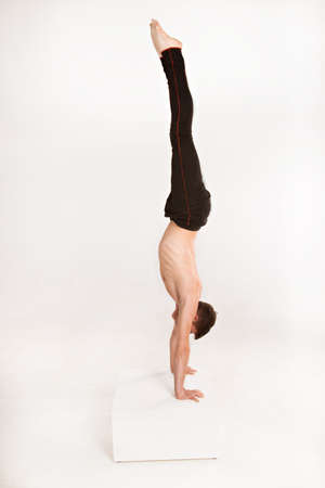 slender man doing gymnastic exercises. Gymnast standing on handsの写真素材