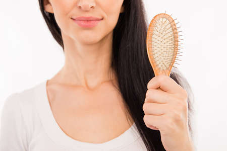 Happy cute young woman holding hairbrush