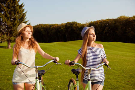 pretty girls with a hats enjoying the sun with a bicycle