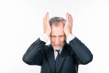 Terrible headache. Old man in suit touching his head and keeping eyes closedの写真素材
