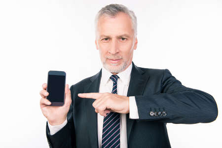Old handsome businessman pointing to the smartphoneの写真素材