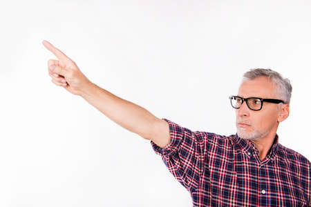 Confident gray aged man with glasses pointing awayの写真素材