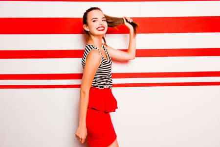 Side view of glamorous girl posing against the striped background