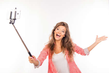 Happy nice-looking young woman  with hat making selfie photo with stickの写真素材