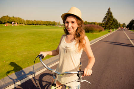 happy cute girl with hat riding bikeの写真素材