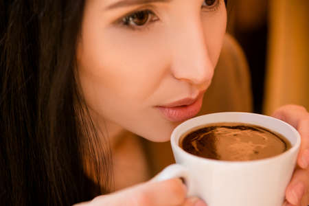 Charming young woman enjoying coffeeの写真素材