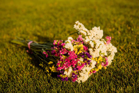 Nice multicoloured bouquet on the green grassの写真素材