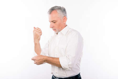 Handsome confident businessman with gray beard wrapping sleevesの写真素材