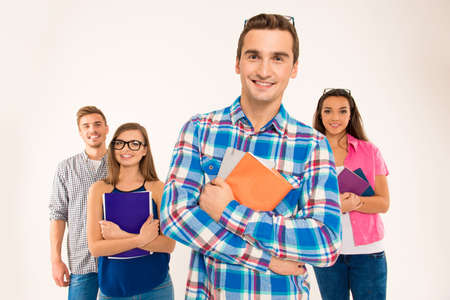 Happy confident group of students holding books and materialsの写真素材