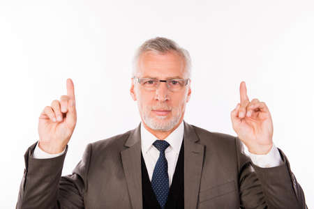 Portrait of businessman in an elegant suit with glasses pointing upの写真素材