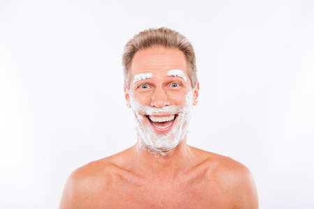 Handsome funny  man with shaving foam on his chin and eyebrowsの写真素材