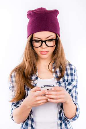 sexy beautiful girl in a hipster hat holding mobile phoneの写真素材