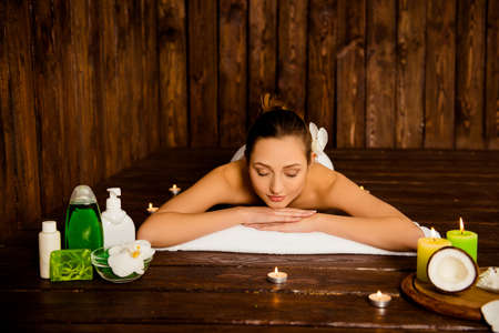 Pretty young woman laying in spa salon with closed eyes and relaxedの写真素材