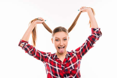 Cute girl joking with protruding tongue and funny bunchesの写真素材