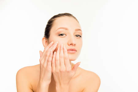 Portrait of cute young lady touching  faceの写真素材