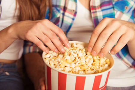 young woman and man  eating popcorn in the cinemaの写真素材