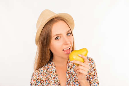 Portrait of nice smiling girl with beautiful smile, biting a pear