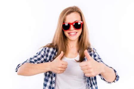 Happy girl in glasses with a red rim showing thumbs upの写真素材