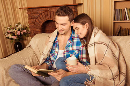 Portrait of cute young couple spending time together with a bookの写真素材