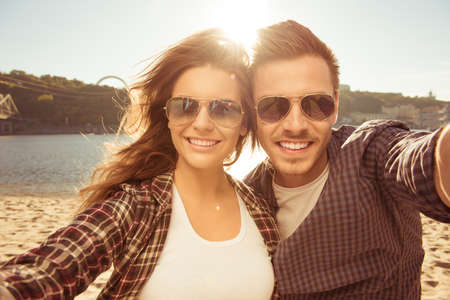 Two lovers making a selfie photo near the river, close-up photo