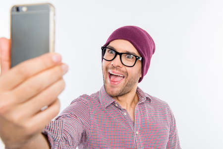 Smiling man in cap and glasses making comic selfieの写真素材