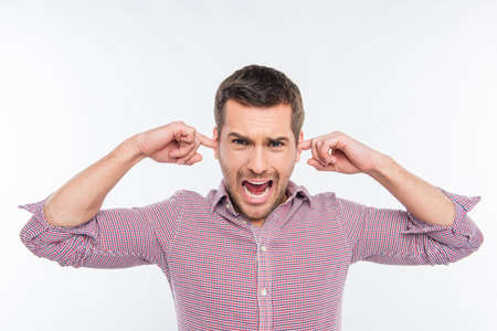 Attractive man clossing his ears and screaming