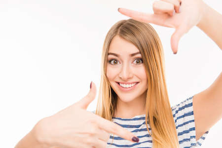 Cheerful young woman gesturing finger frame and smiling, close up photo