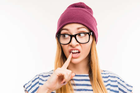 Close up photo of  girl in hat and glasses touching her teethの写真素材