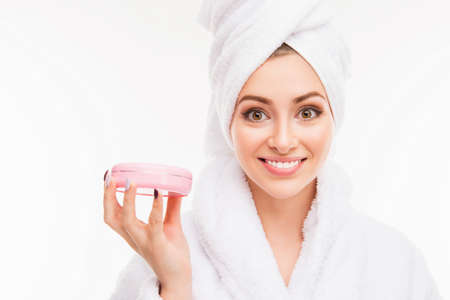 Close up photo of  cute girl with towel on her head holding creamの写真素材