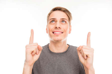 Smilling handsome man gesturing and pointing up