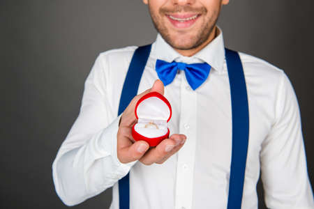 Happy romantic man making a marriage proposal with box with ringの写真素材