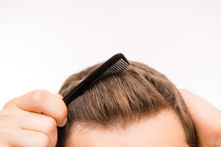 Close-up photo of a amn brushing his hair