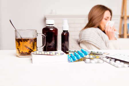 Sick woman, cup of tea, pills and mixture, close up photo Sick woman, cup of tea, pills and mixture, close up photo