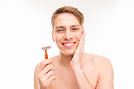 Handsome happy man holding razor on white backgroundの写真素材