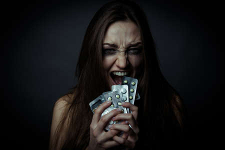 Young depressed woman ussing pills or drugs