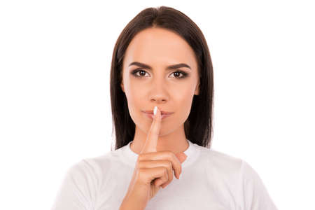 Close up portrait of pretty young woman gesturing to make silence