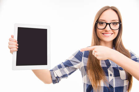 Pretty young girl pointing on screen of tablet
