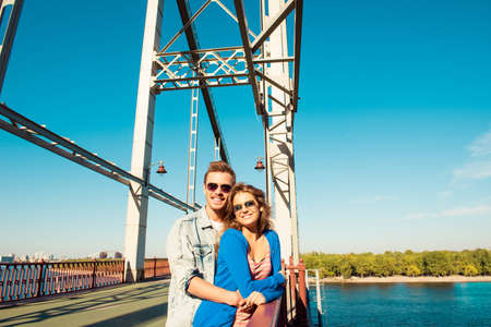 Cheerful couple in love embracing each other on the bridgeの写真素材