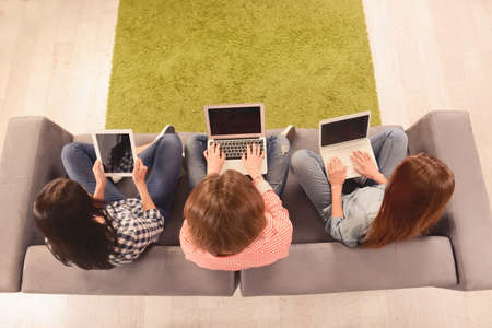 Top view photo of three girls working on laptop and digital tabletの写真素材